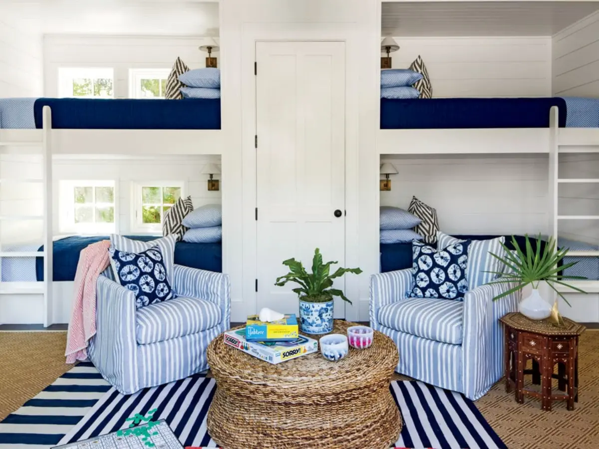 campingplatz mit bungalow am see wohnzimmer mit zwei hochbetten und zwei sessel streifen blau weiss teppich in streifen