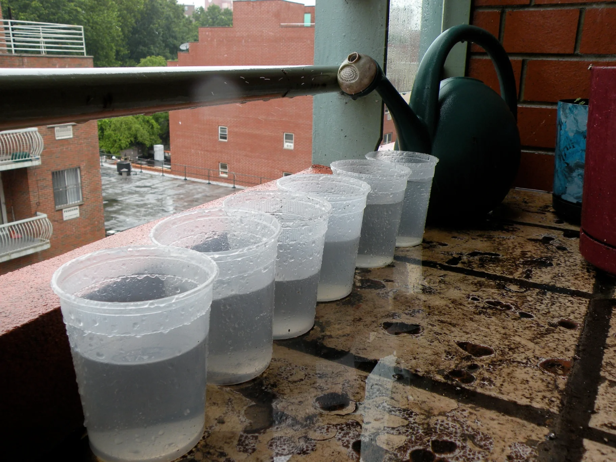 mit regenwasser gefüllte plastikkanister auf einem balkon