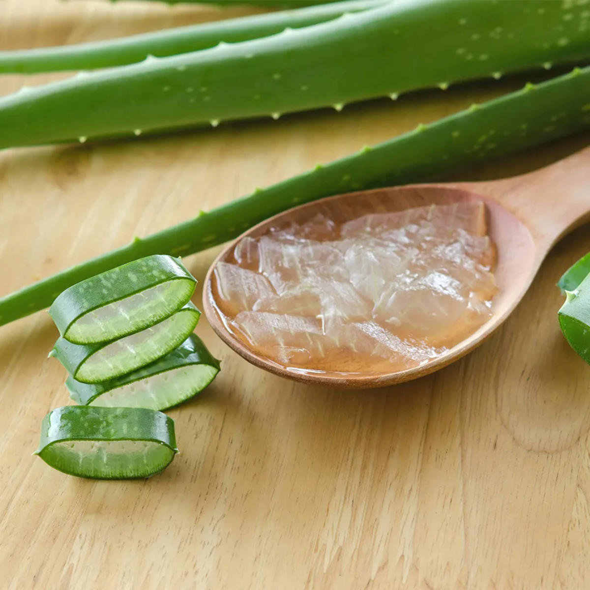 aloe vera gel in holzlöffel auf holztisch