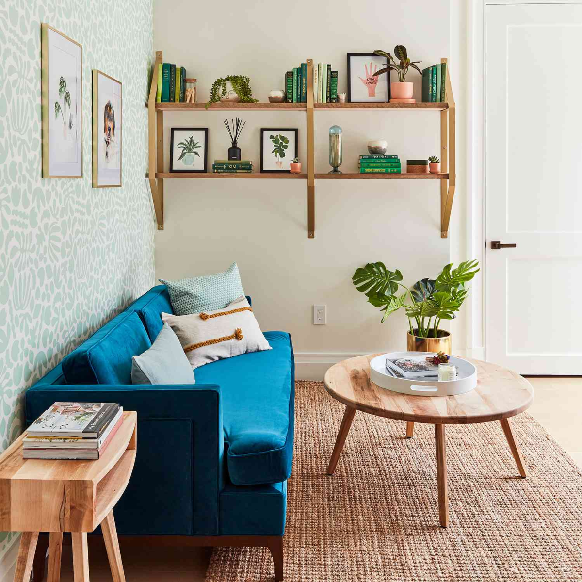 mietwohnung mit blauer couch, dekoriert mit büchern, bildern und blumen