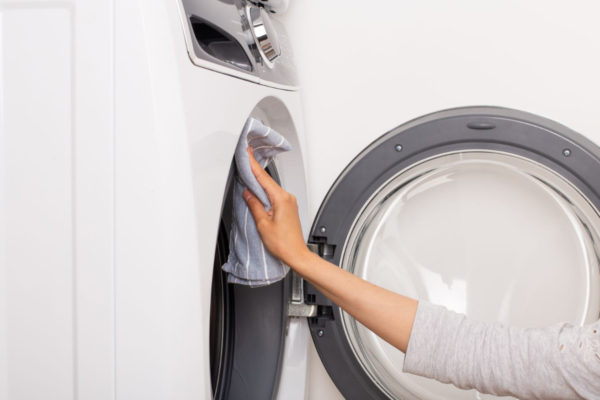 reinigen aller teile der waschmaschine mit blauem handtuch