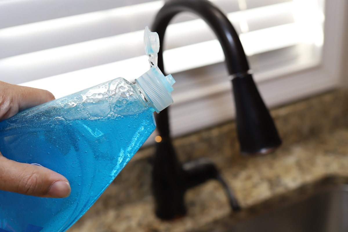 blaues geschirrspülmittel und heißes wasser zum reinigen des abflusses
