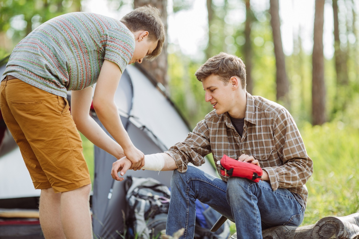 ein junge verbindet die hand eines anderen jungen während eines campingausflugs