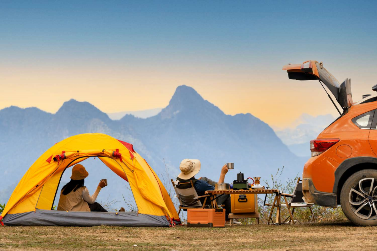 eine familie die camping machen und urlaub mit dem auto vornehmen