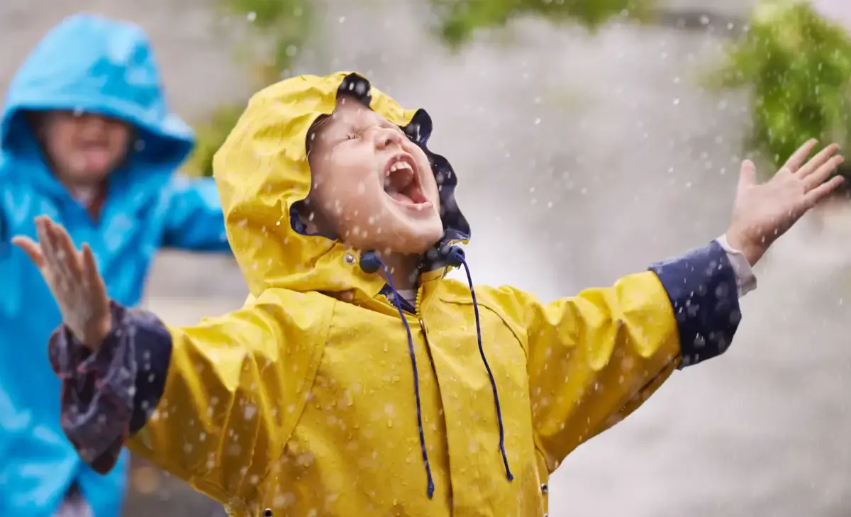 regentag kinder spielen outdoor junge gelber regenmantel