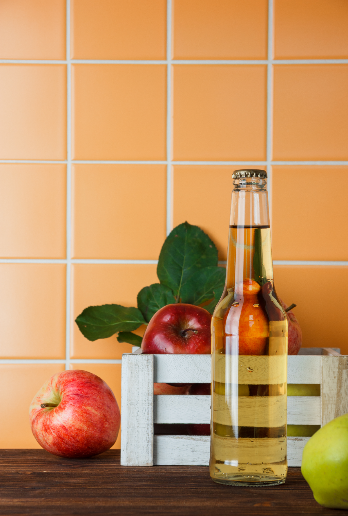 side view apples with apple juice box wooden orange tile background vertical space text