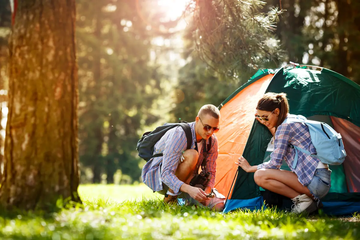 sommertage campen im sommer mann und frau setzen ein zelt