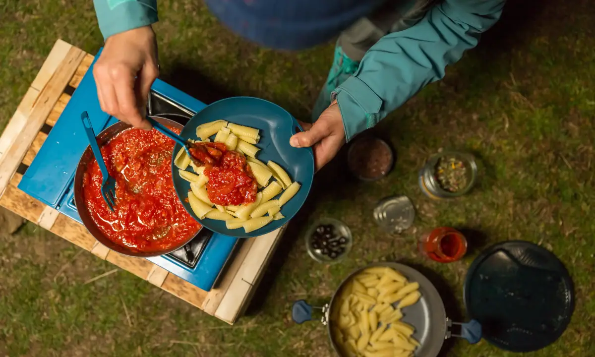 was kann man beim camping gut essen beim campen im sommer kochen frau kocht pasta am camping