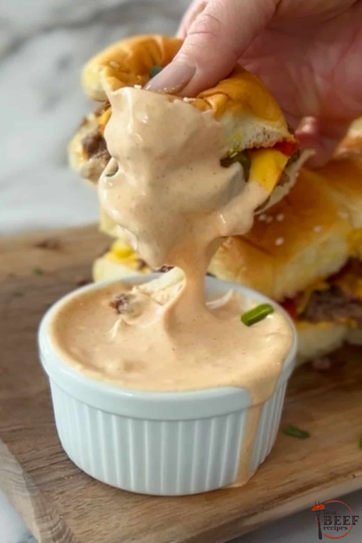 dippen eines burgers in hausgemachter amerikanischer burgersauce