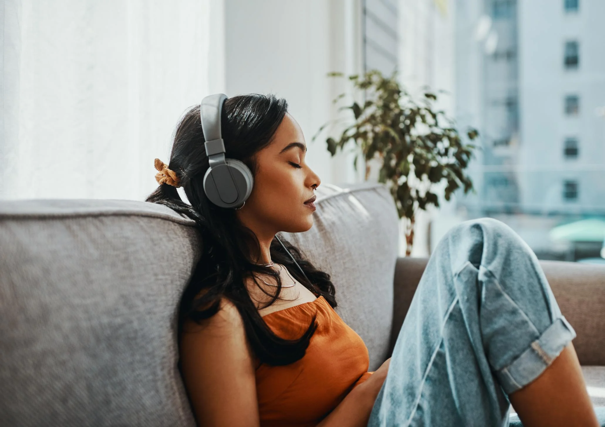 frau, die über kopfhörer musik hört, um stress zu reduzieren