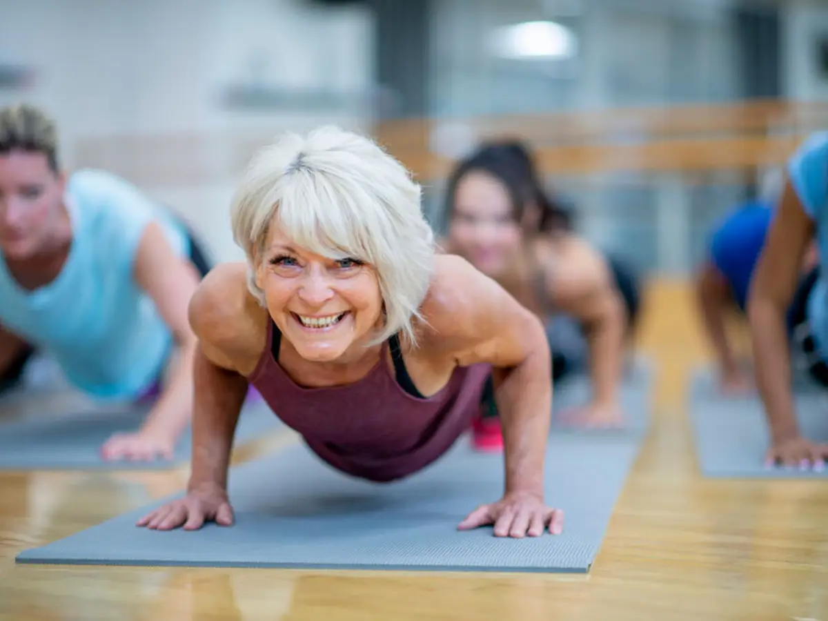 effektives bauchtraining frauen ab 50 frau im saal macht yoga plank