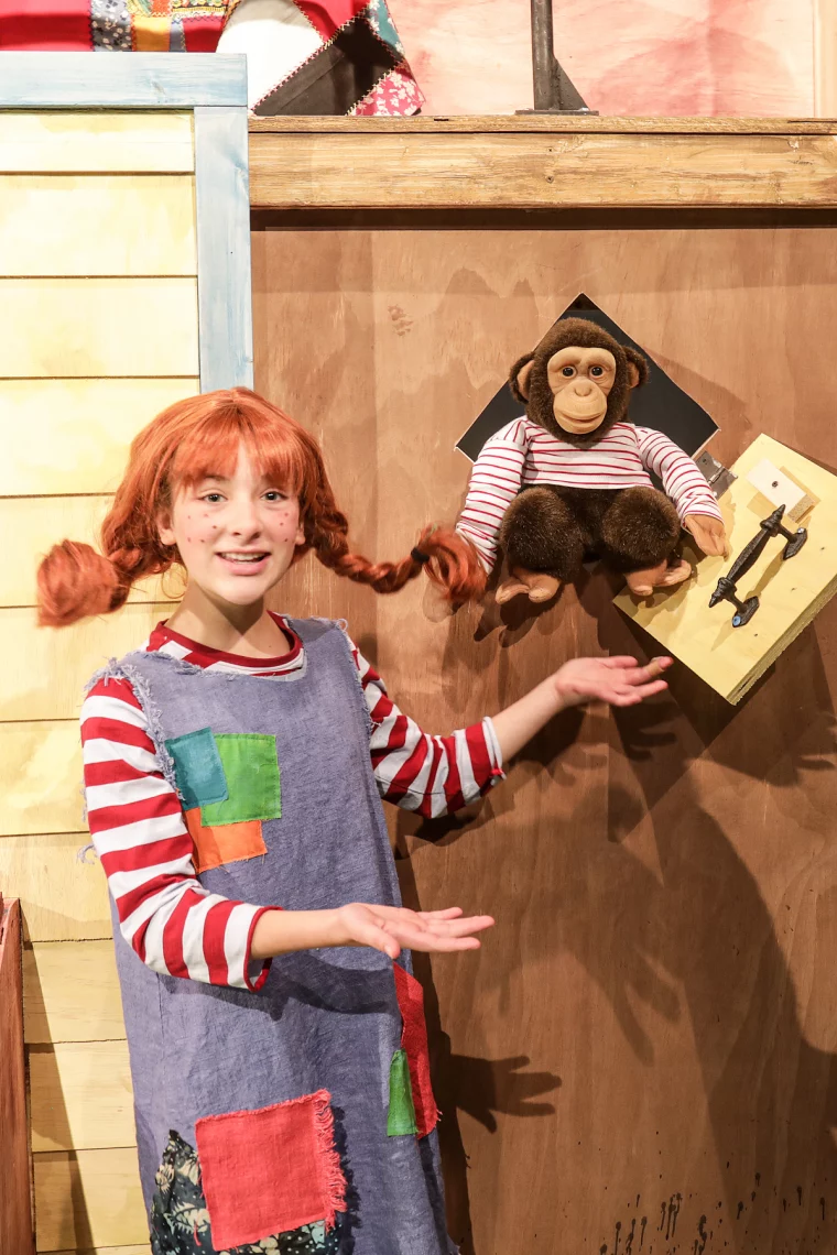 mädchen mit pippi langstrumpf kostüm zeigt affen spielzeug
