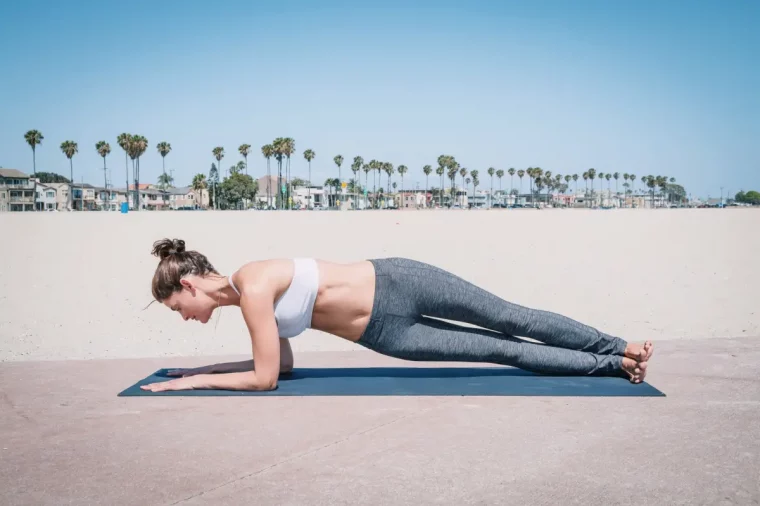 wie lange bauchtraining bis man was sieht frau macht plank hip twist am strand