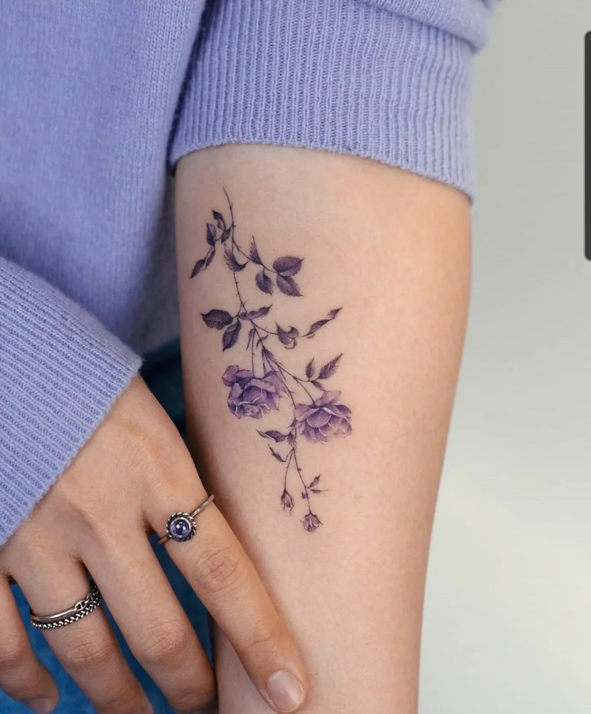 zartes blumen tattoo am unterarm in lila