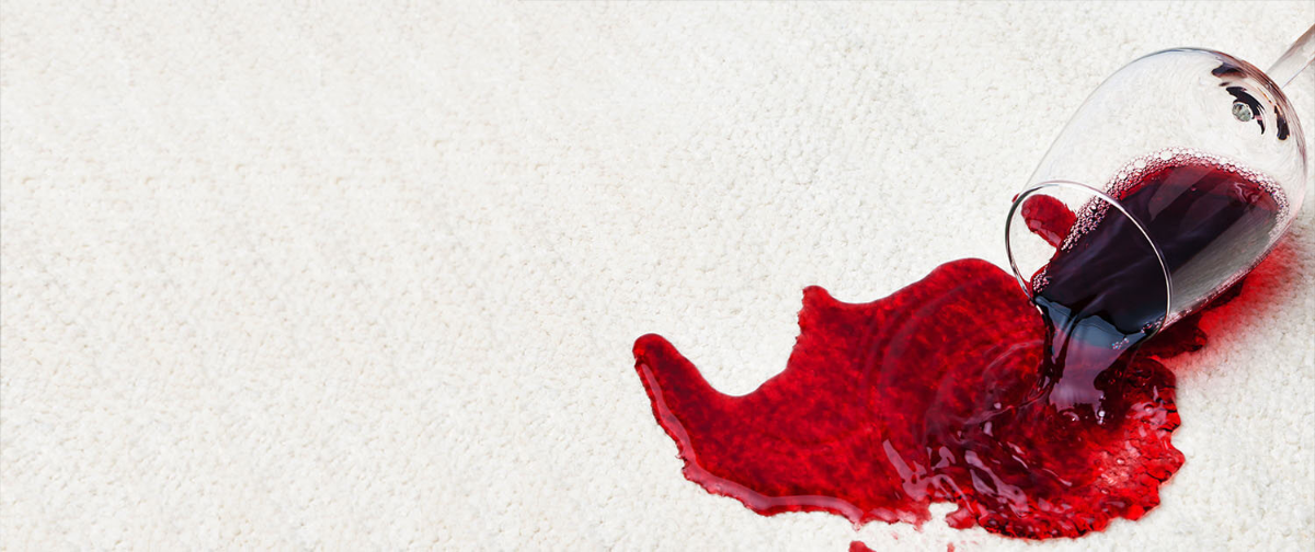 rotwein verschüttet auf weißem teppich