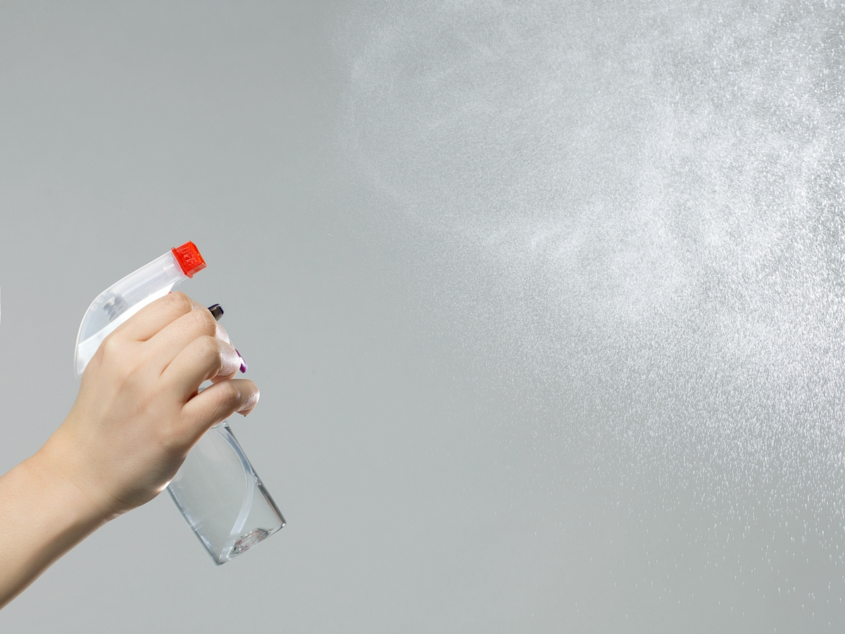 frau die raum reinigt spray erfrischungsspray zimmer