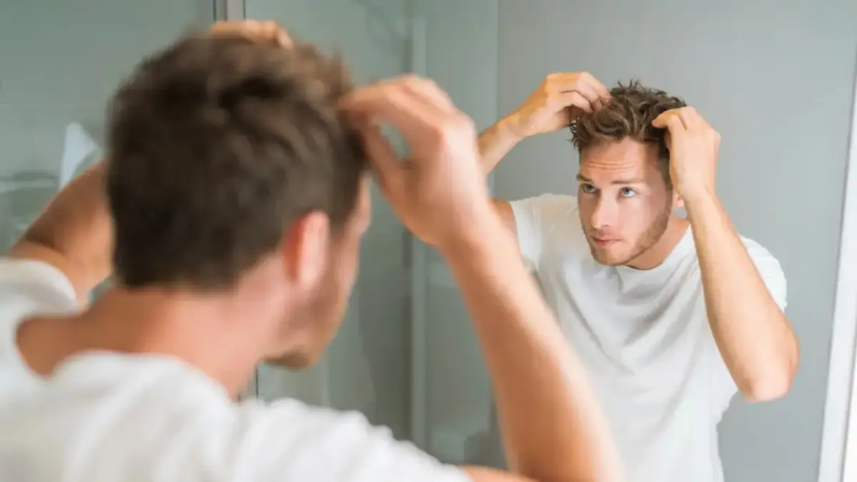 warum wachsen meine haare nicht haarwachstum anregen bei maennern junger mann schaut sich im spiegel haarwachstum