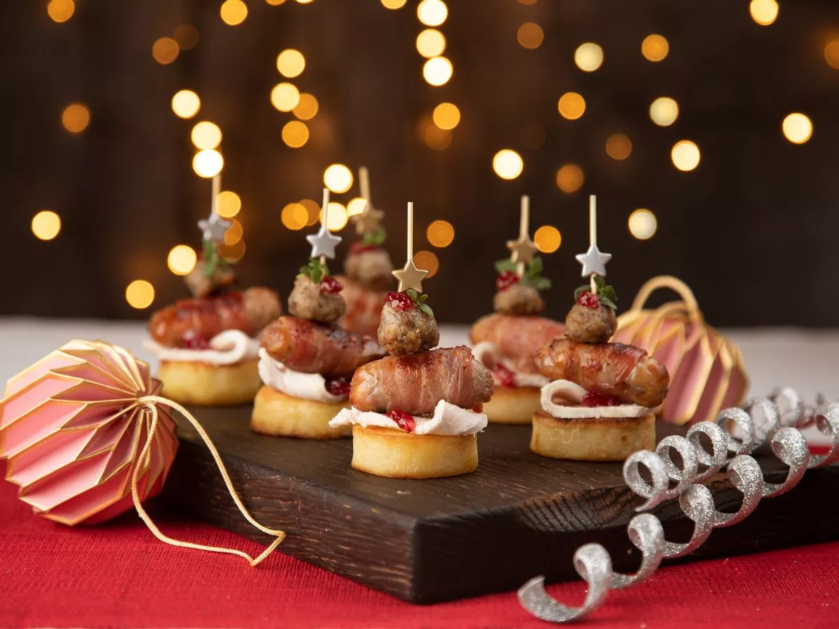 fingerfood häppchen für weihnachten mit lichtern und weihnachtsschmuck
