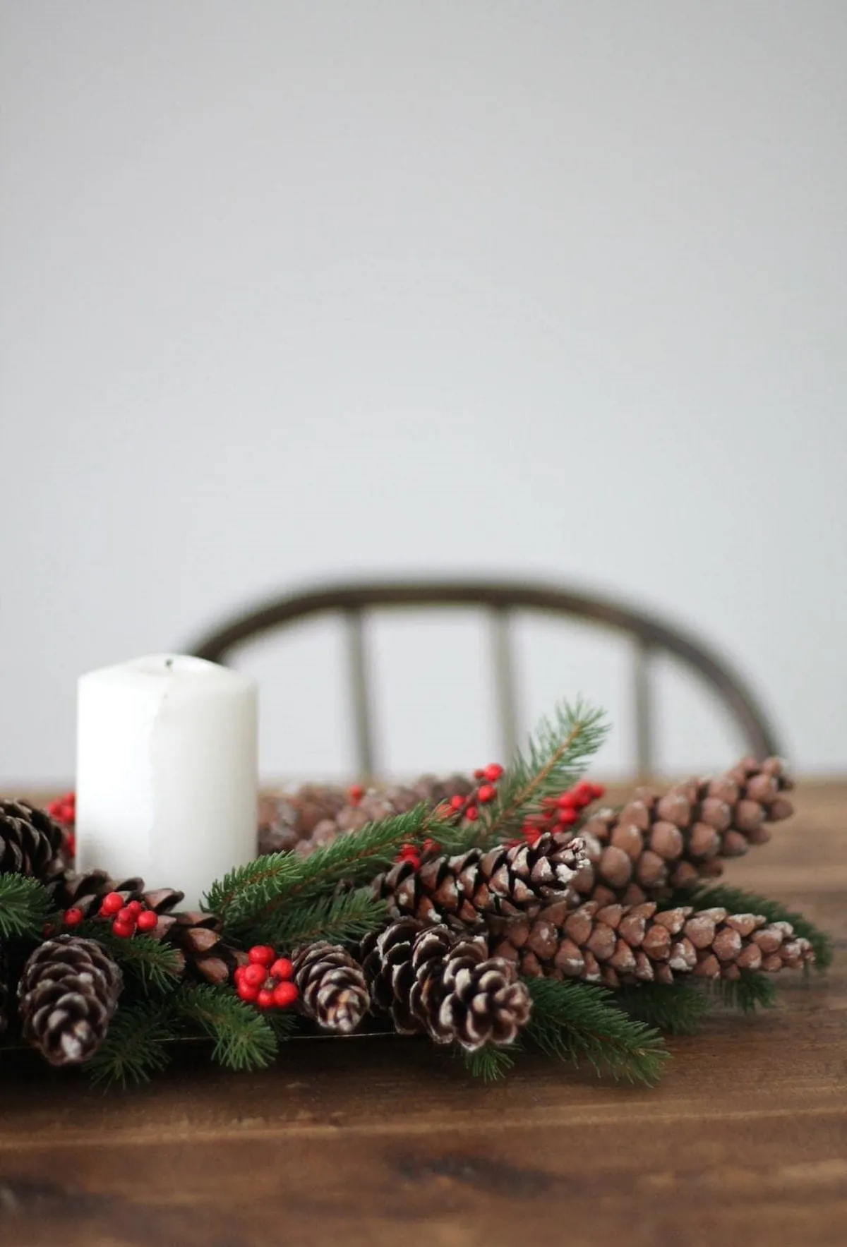 tischdeko zu weihnachten selbstgemacht aus tannenzweigen und zapfen weiße kerze