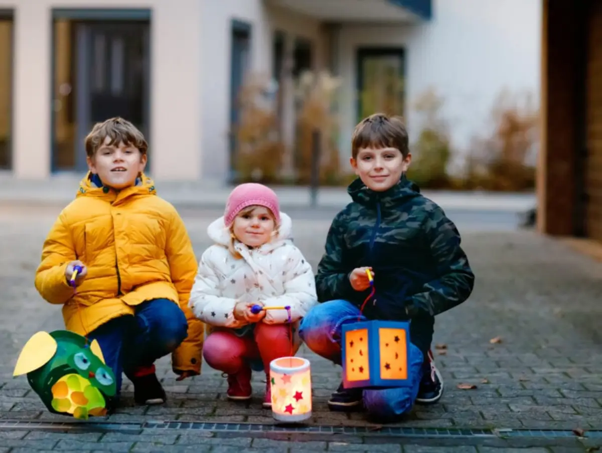 warum feiern kinder laternenfest laternenfest feiern drei kinder an der strasse tragen laternen