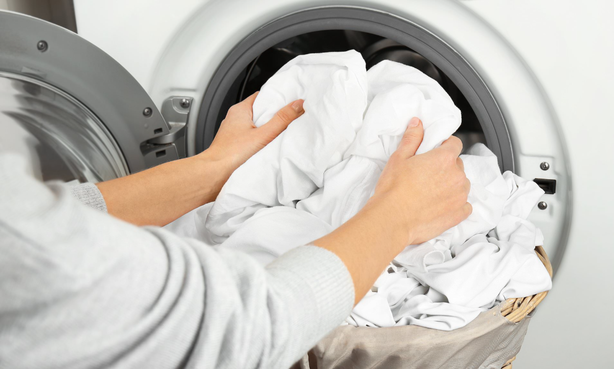 weiße bettwäsche in die waschmaschine stecken