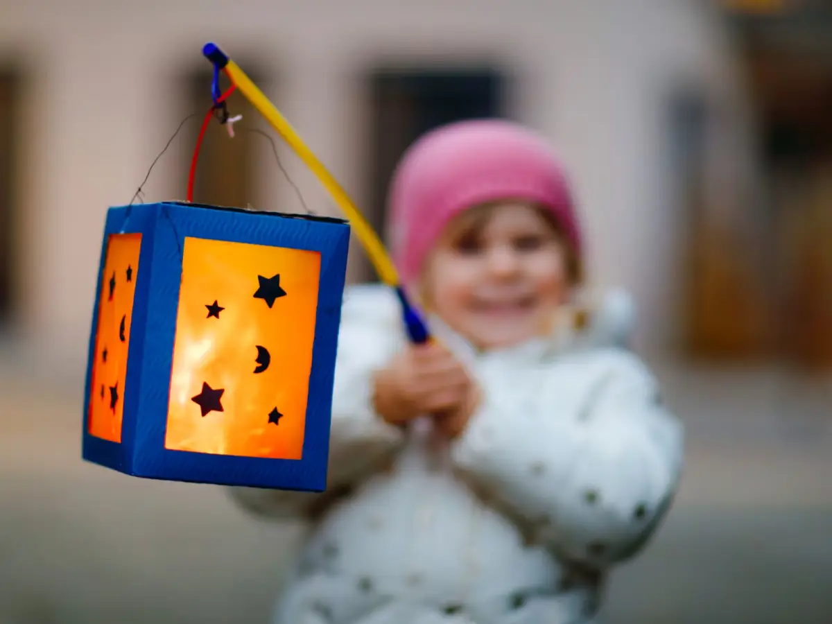 wie feiert man laternenfest kinder und erwachsene feiern laternenfest kleines maedchen haelt selbst gemachte laterne