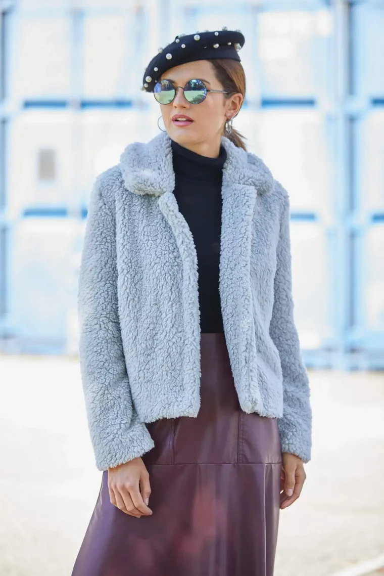 winterjacken trend 2023 24 damen frau in teddy jacke kunststoff himmelblau lederrock in bordeaux muetze