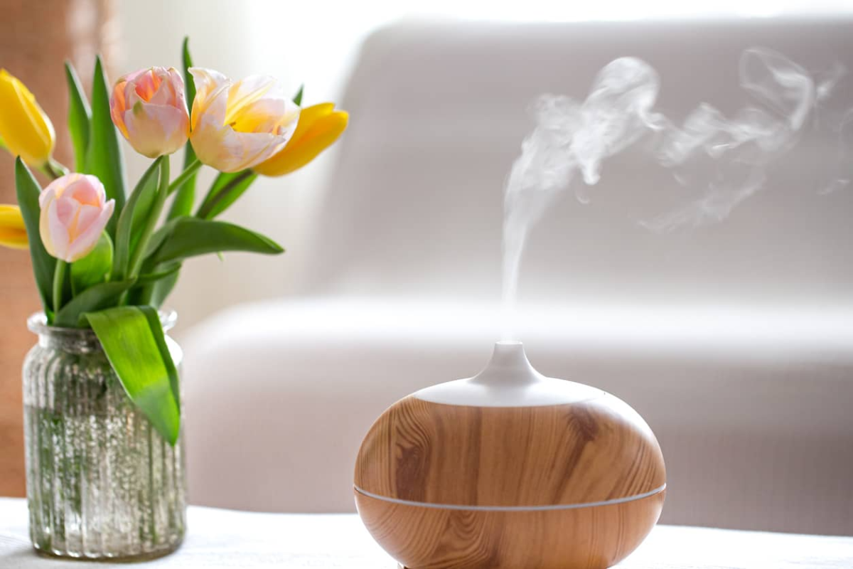 diffusor mit ätherischem Öl für die aromatherapie neben den tulpen