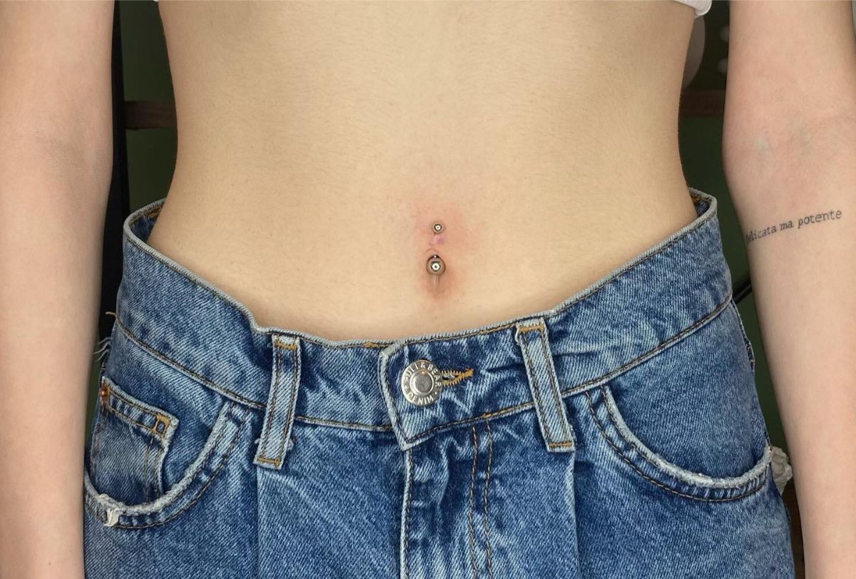 frau mit jeans hat piercing am bauch