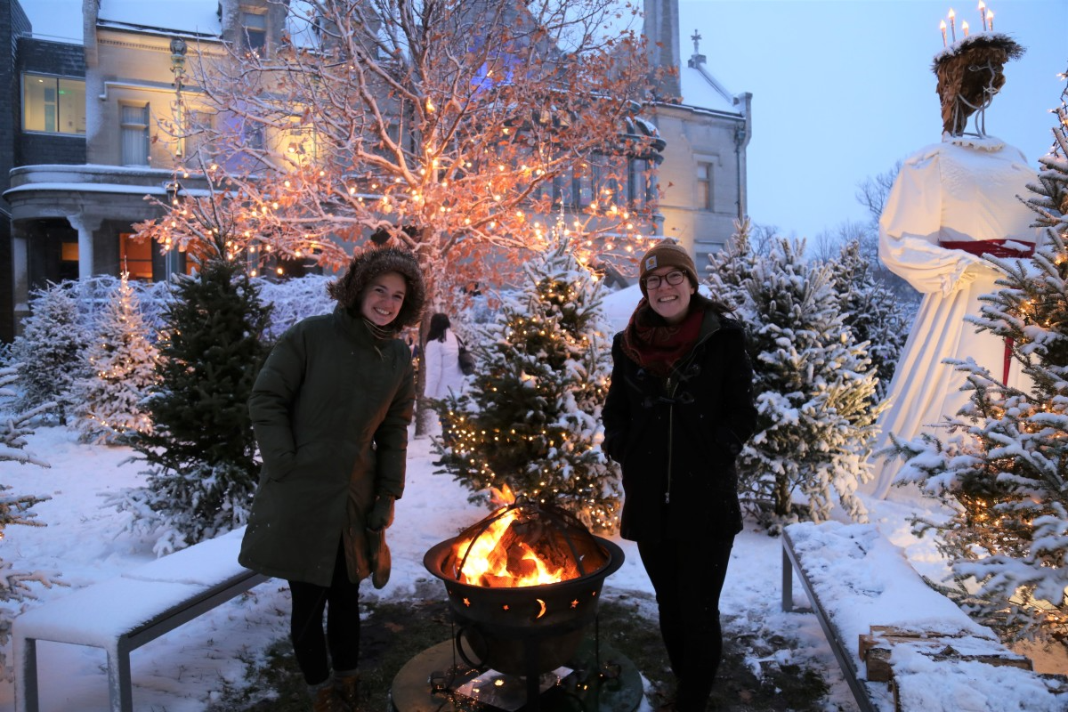 menschen beim feiern der wintersonnenwende zwischen weihnachtsdekoration und neben dem feuer
