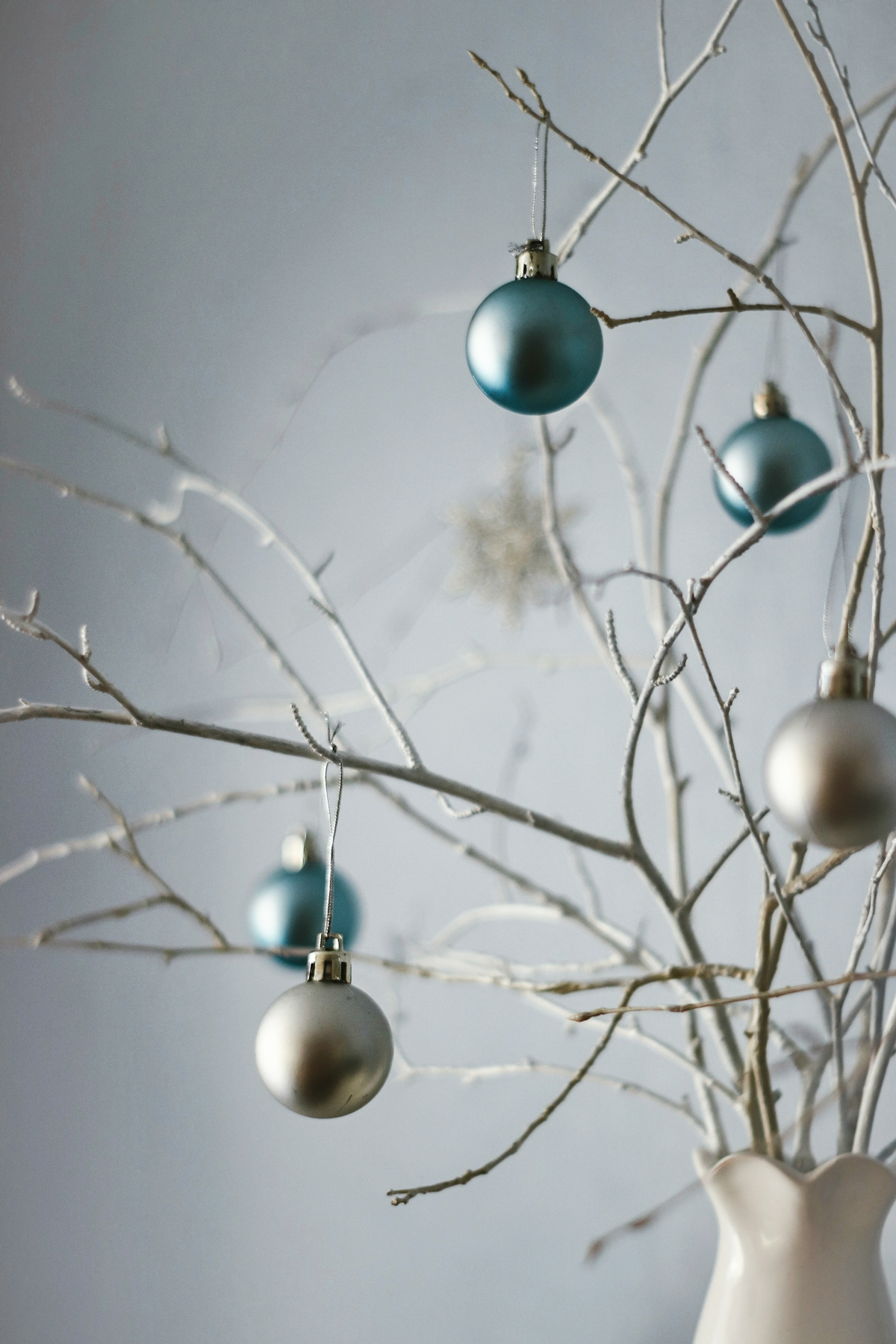ast weihnachtlich dekorieren zweige in vase verziert mit weihnachtskugeln