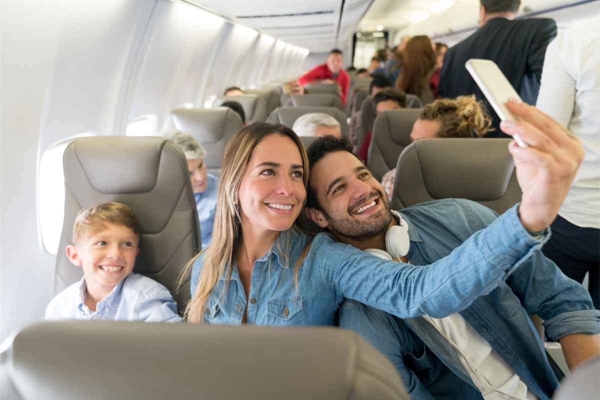 familie aus mutter vater und sohn machen ein selfie im flugzeug