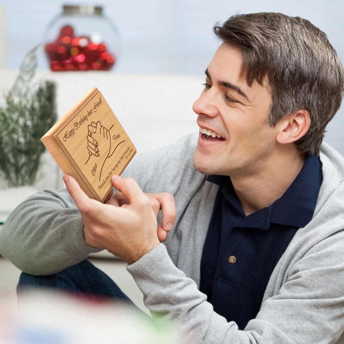 mann liest geburtstagskarte aus holz mit geburtstagswünschen für männer