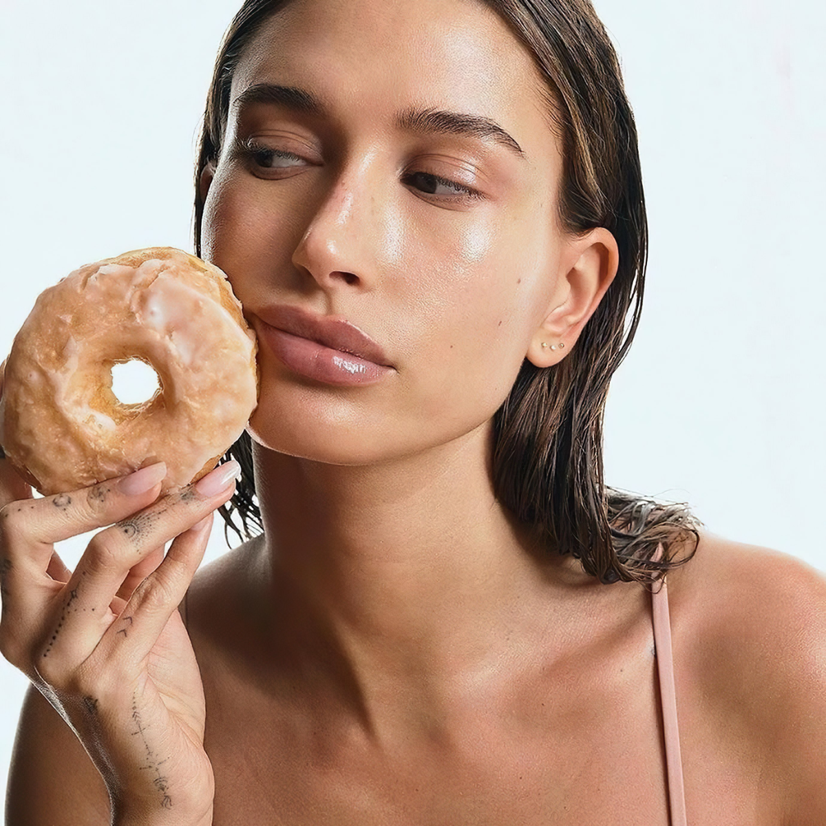 hailey bieber hält donut und mit glazed donut nails
