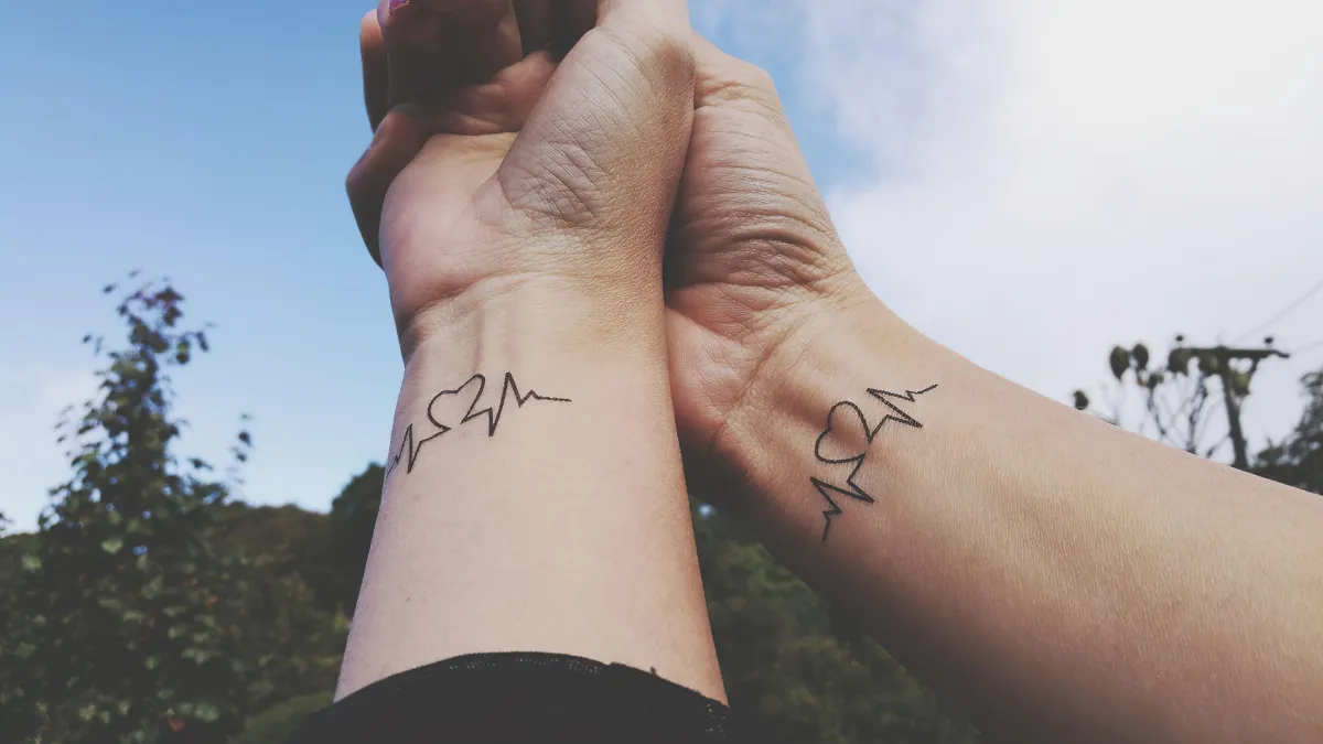 herzschalg partner tattoo am handgelenk