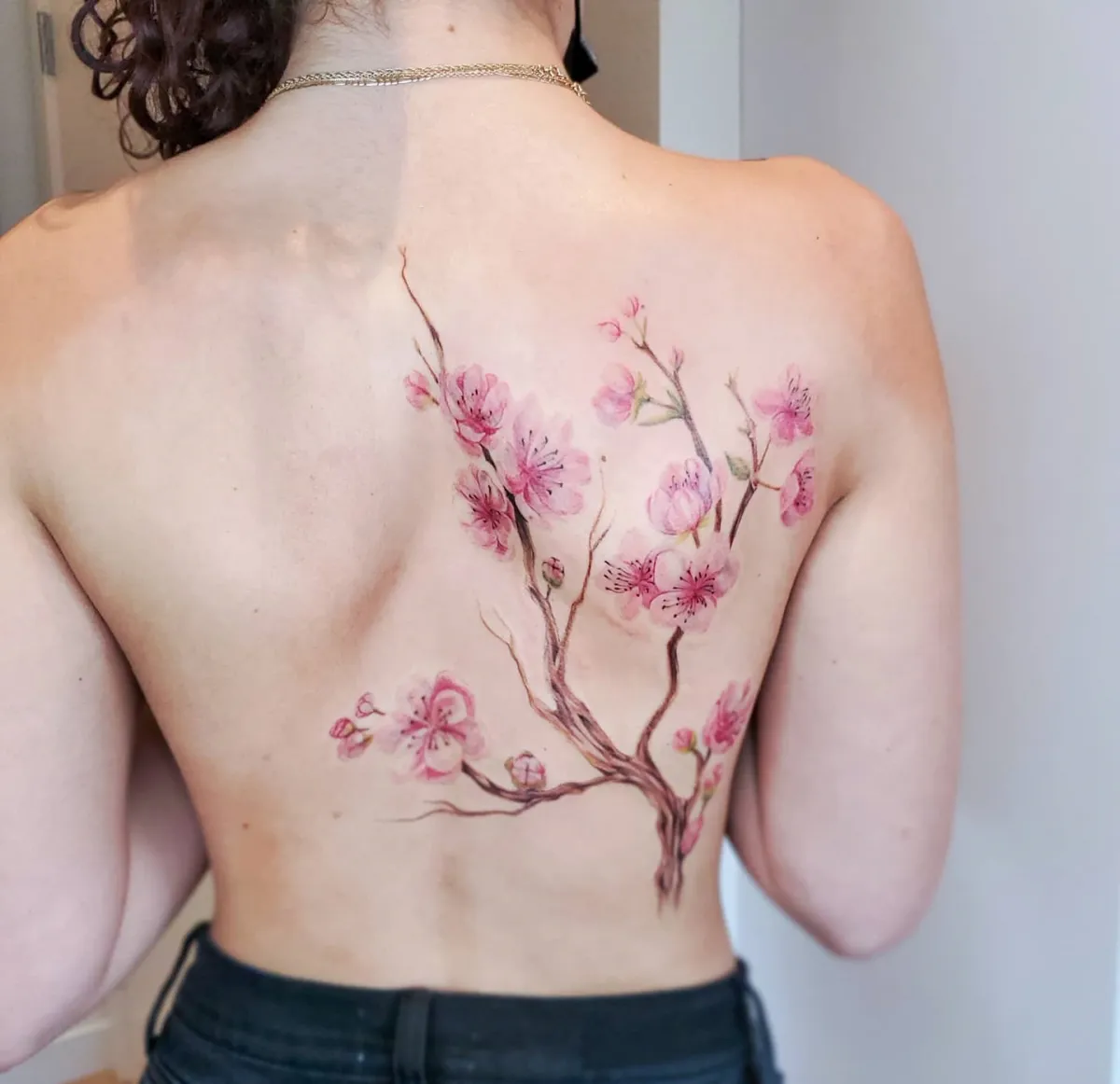 kirschblüte tattoo am rücken feminines motiv