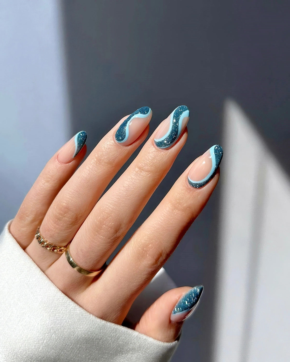 modernes nageldesign swirl nails in blau mit glitzer heluviee