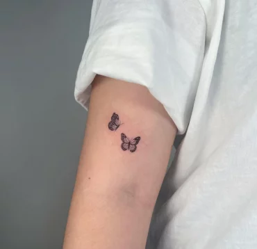 oberarm tattoo zwei schmetterlinge minimalistische motive