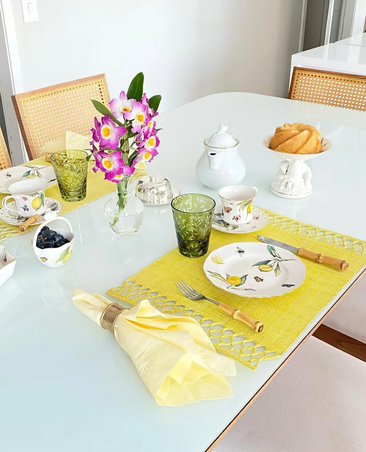 Table decoration in yellow with real flowers, crockery, citrus fruits