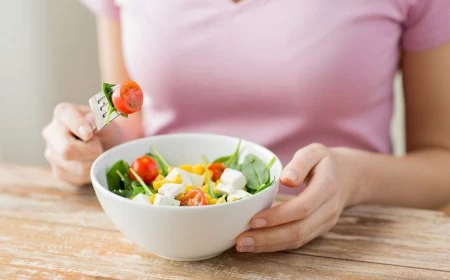 frau isst kleinen salat mit feta und gemuese