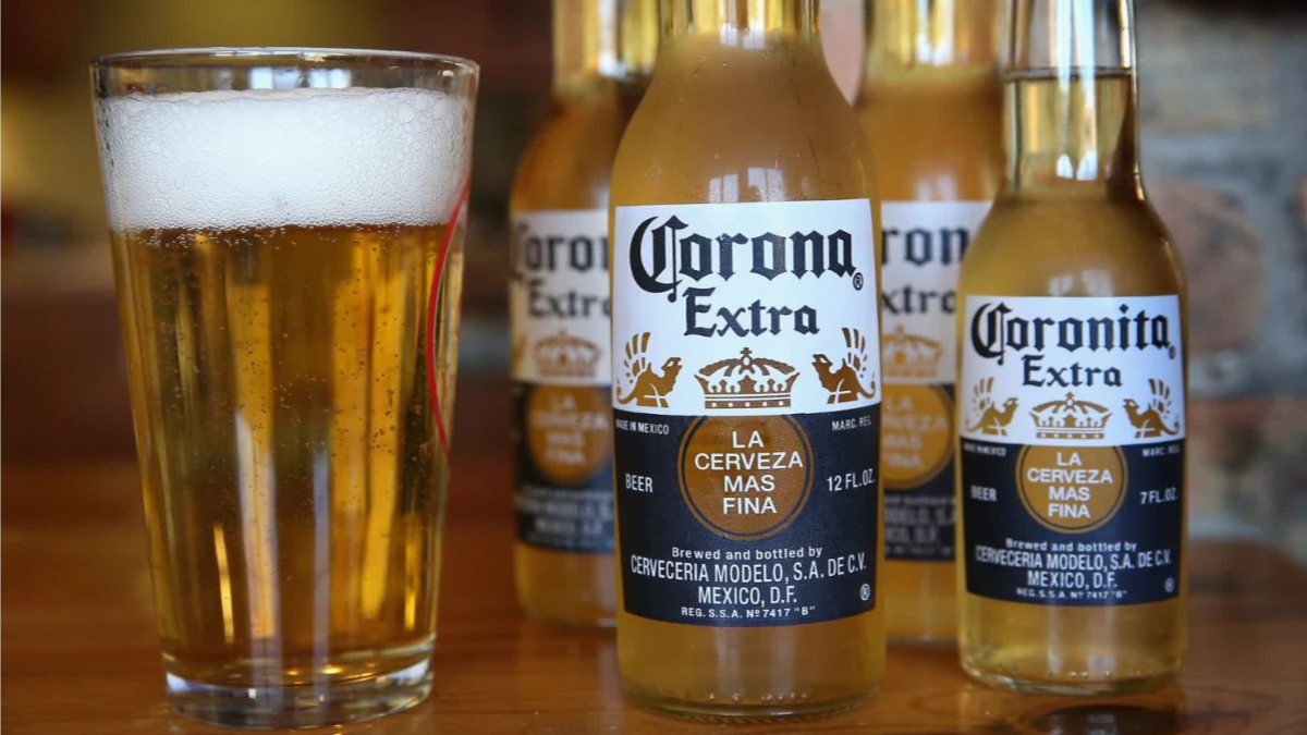 viele flaschen corona bier neben einem glas mit bier
