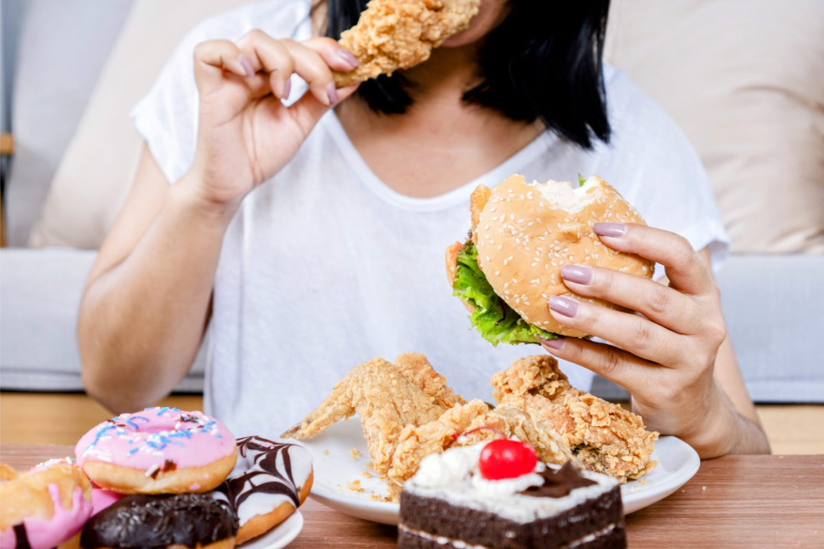 frau isst junkfood und ernährt sich schlecht