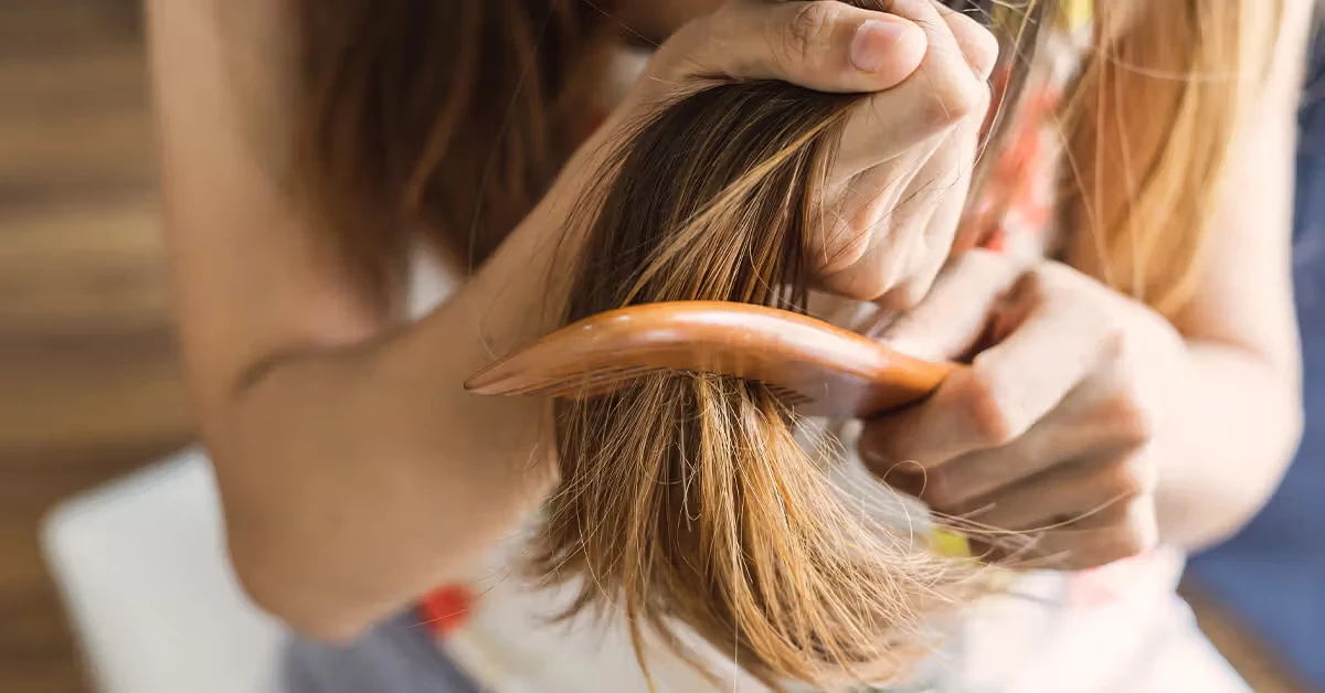 frau kaemmt ihre haare