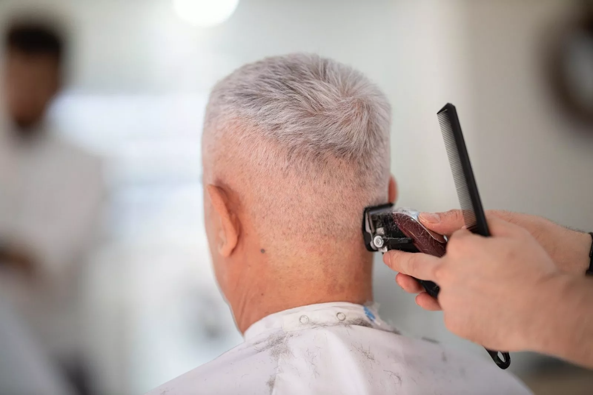 Älterer mann mit weißem haar beim haareschneiden