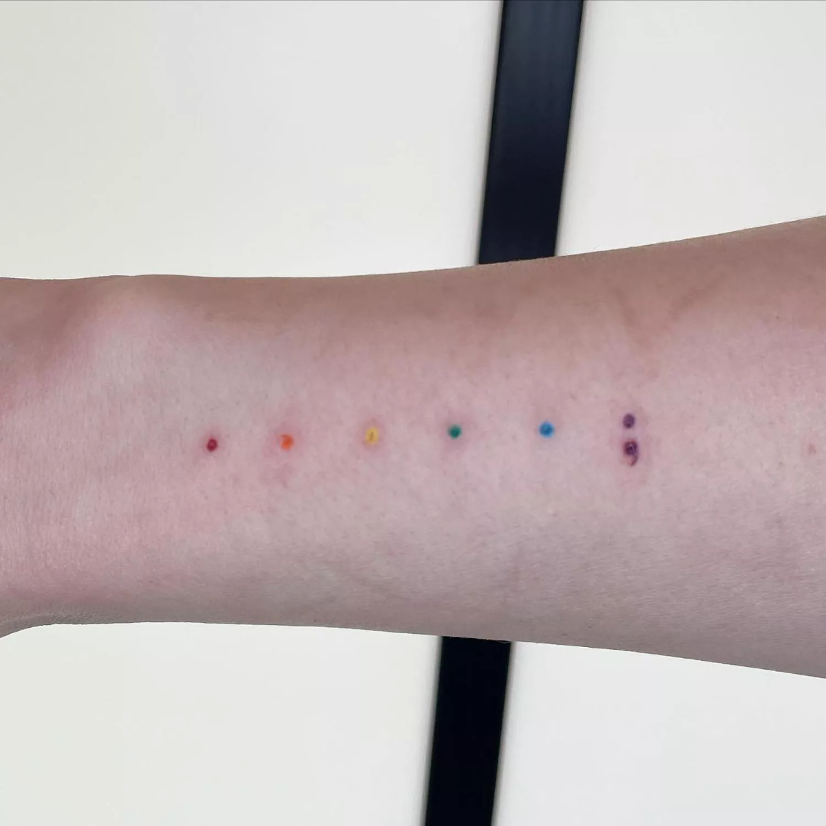 tattoo mit bunten punkten in den regenbogenfarben