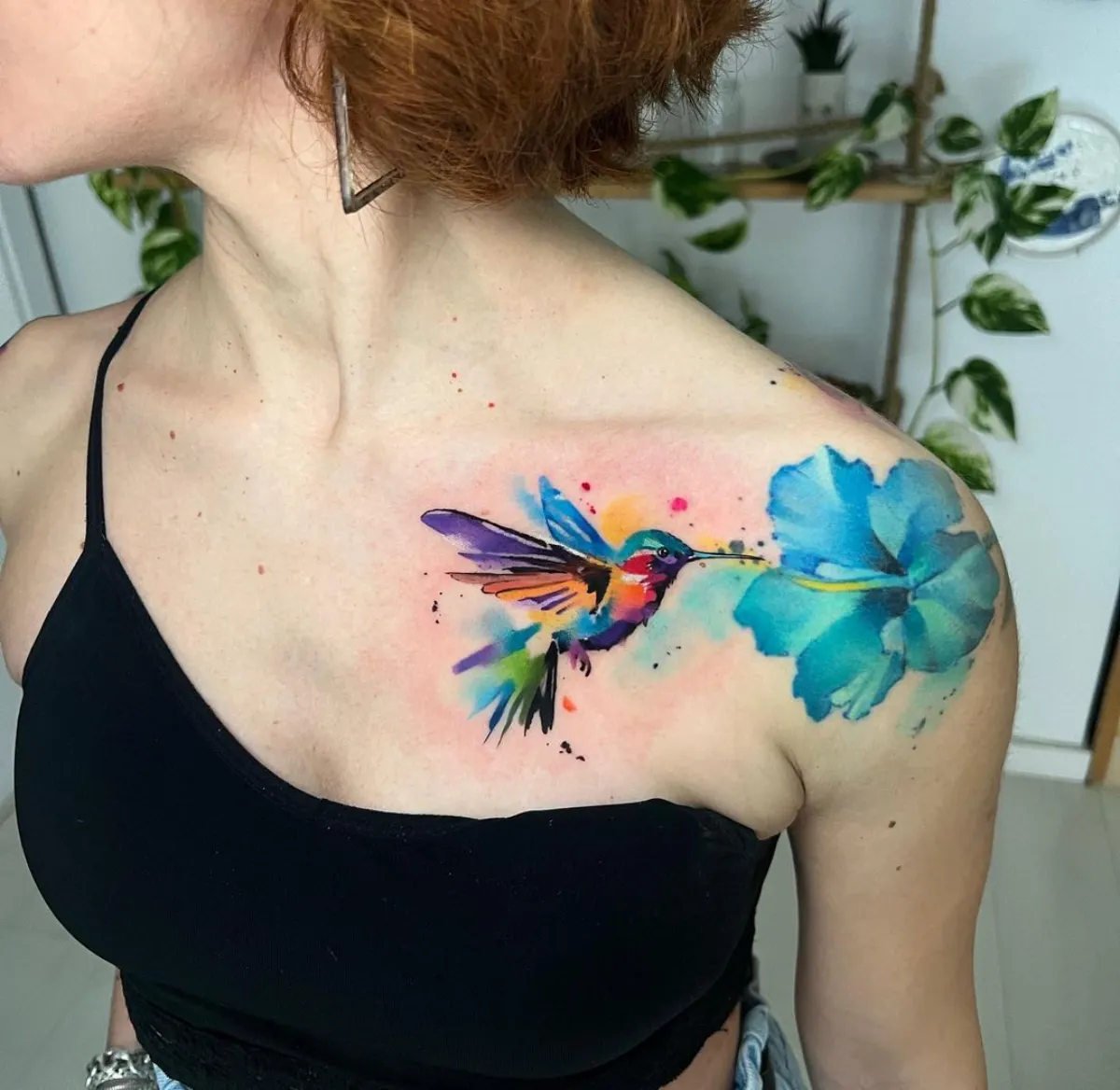 aquarell tattoo kolibri bunt mit bleuer blume am schulter