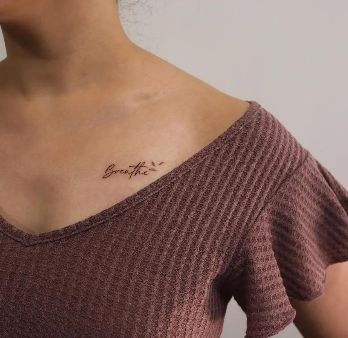 brust tattoo frau inschrift breathe wort