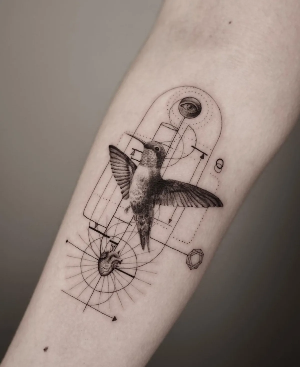detailliertes tattoo kolibri herz auge am unterarm