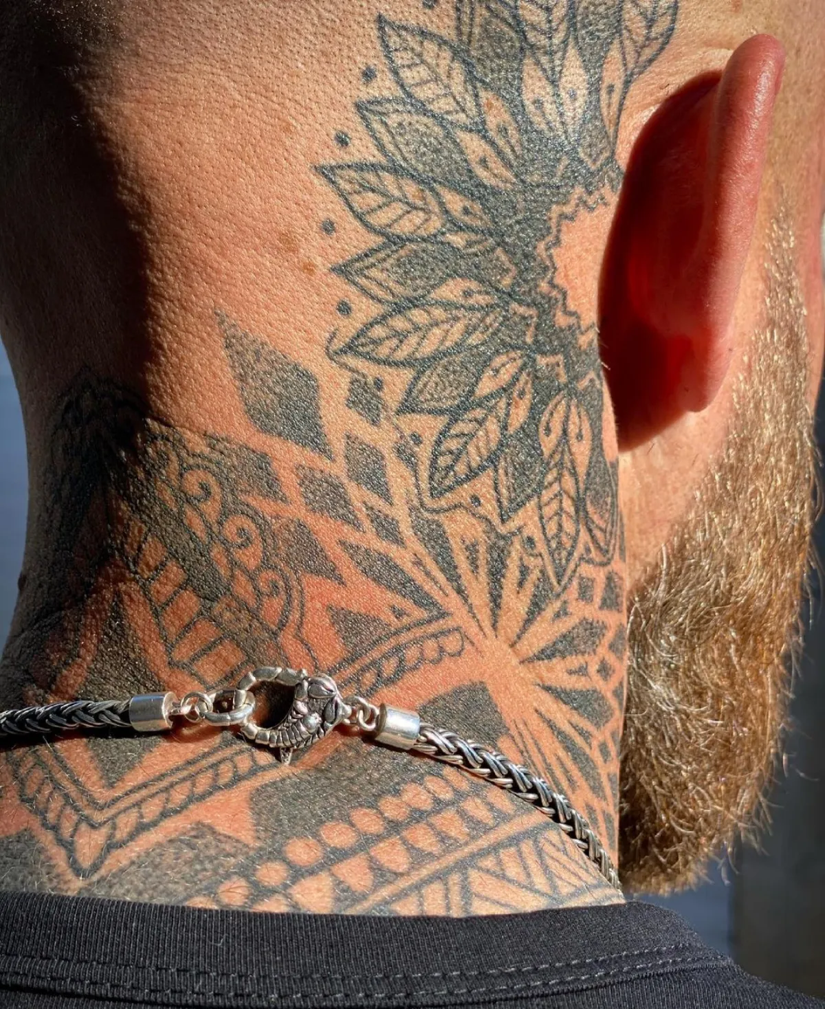 geometrisches tattoo am nacken und hinter dem ohr