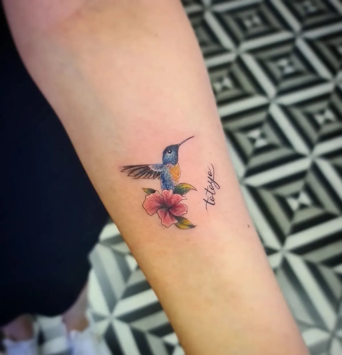 kleines kolibri tattoo blau und gelb mit roter blume